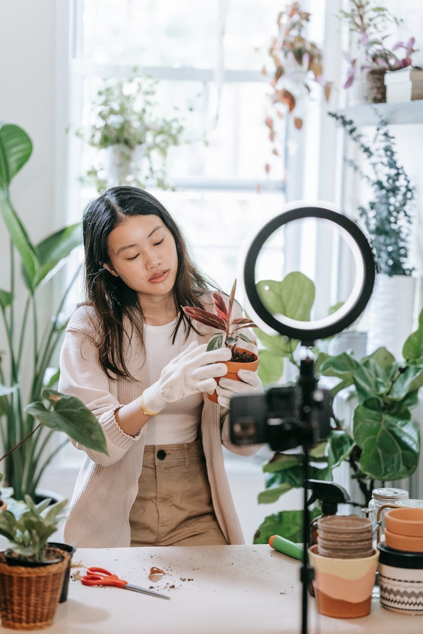 Asian woman demonstrates indoor gardening techniques on her vlog.